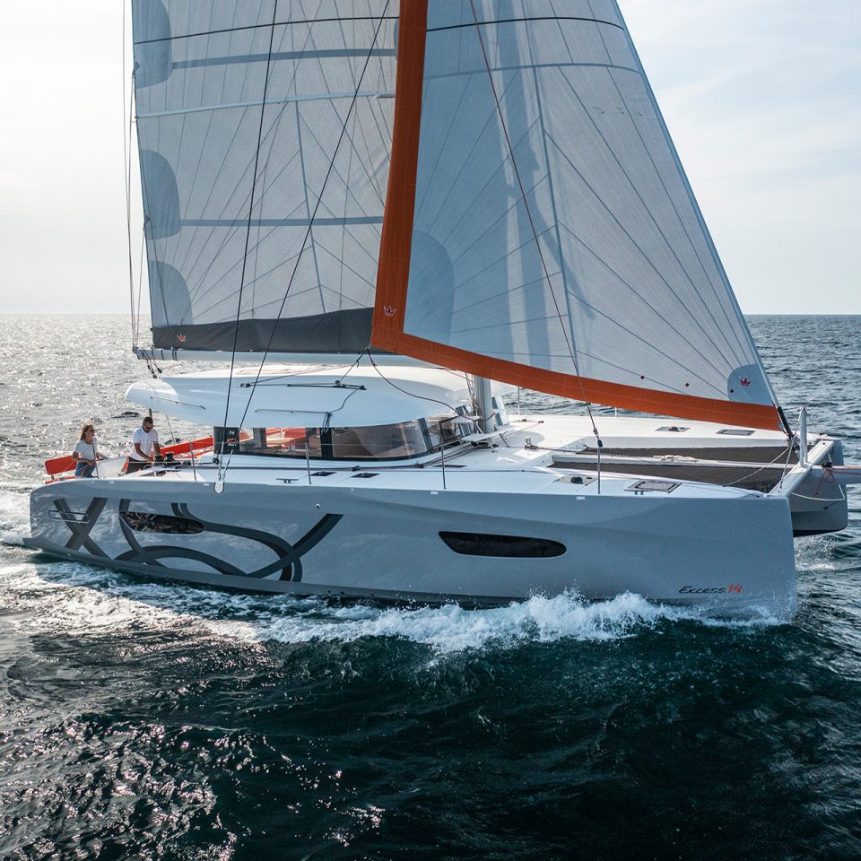 Couple sailing Excess 14 catamaran sailboat on sea