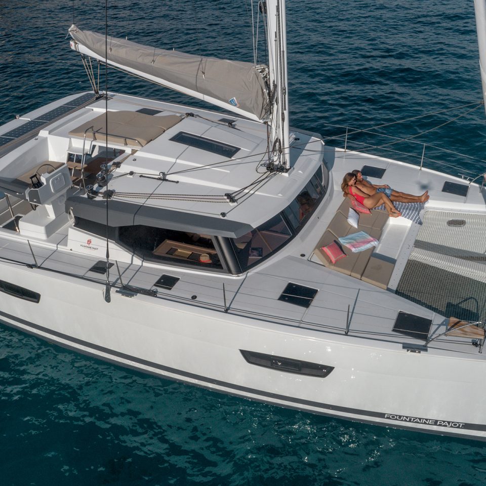 Couple on sunbed lounge of Fountaine Pajot Astrea 42 catamaran