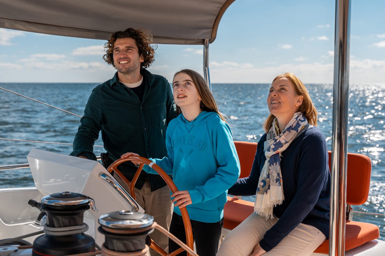 Family at helm sailing Excess 14 catamaran sailboat