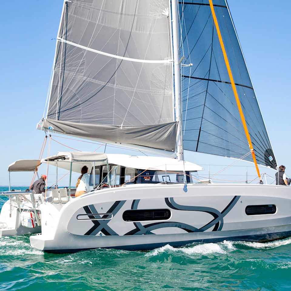 Excess 11 catamaran cruising with sails up