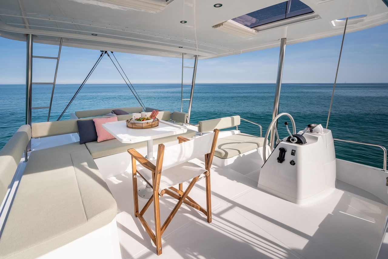 Large seating area with dining table and helm on the Bali 4.6 flybridge