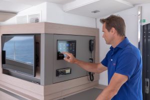 Man using interior electronics panel on the Fountaine Pajot 67 catamaran