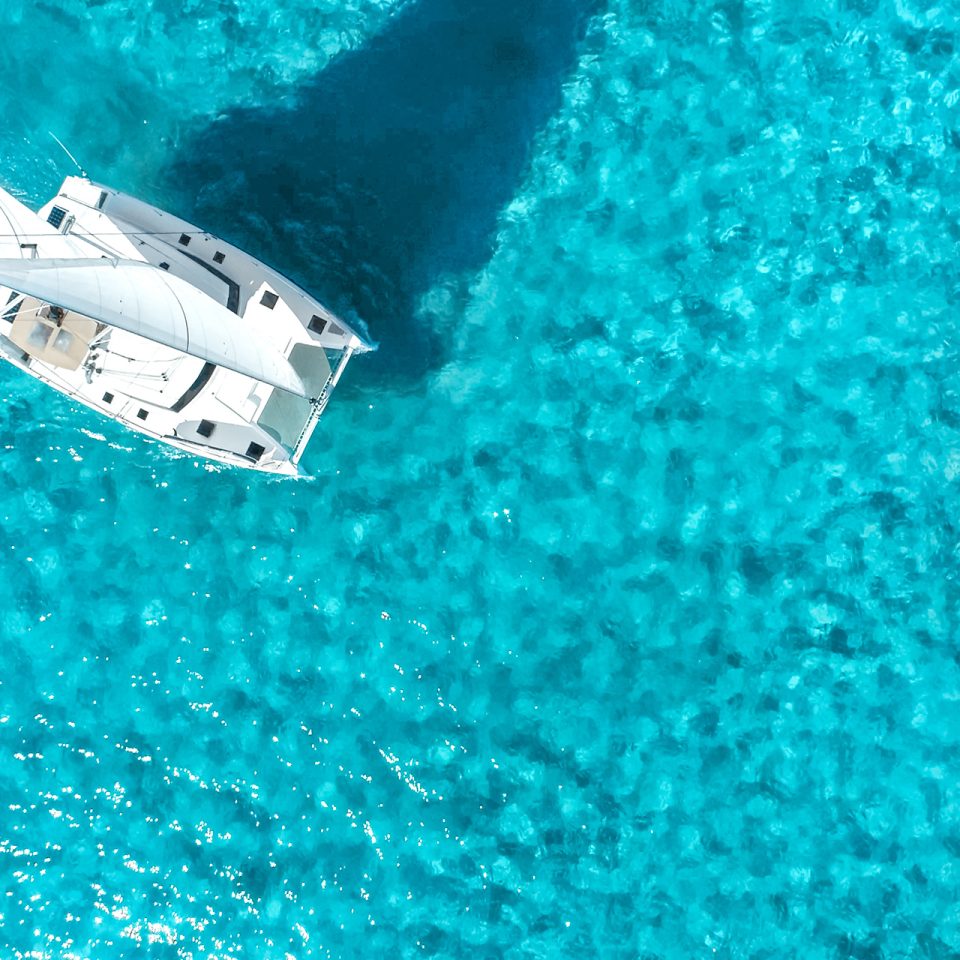 Dream Yacht birdseye view of catamaran sailing in bright blue water