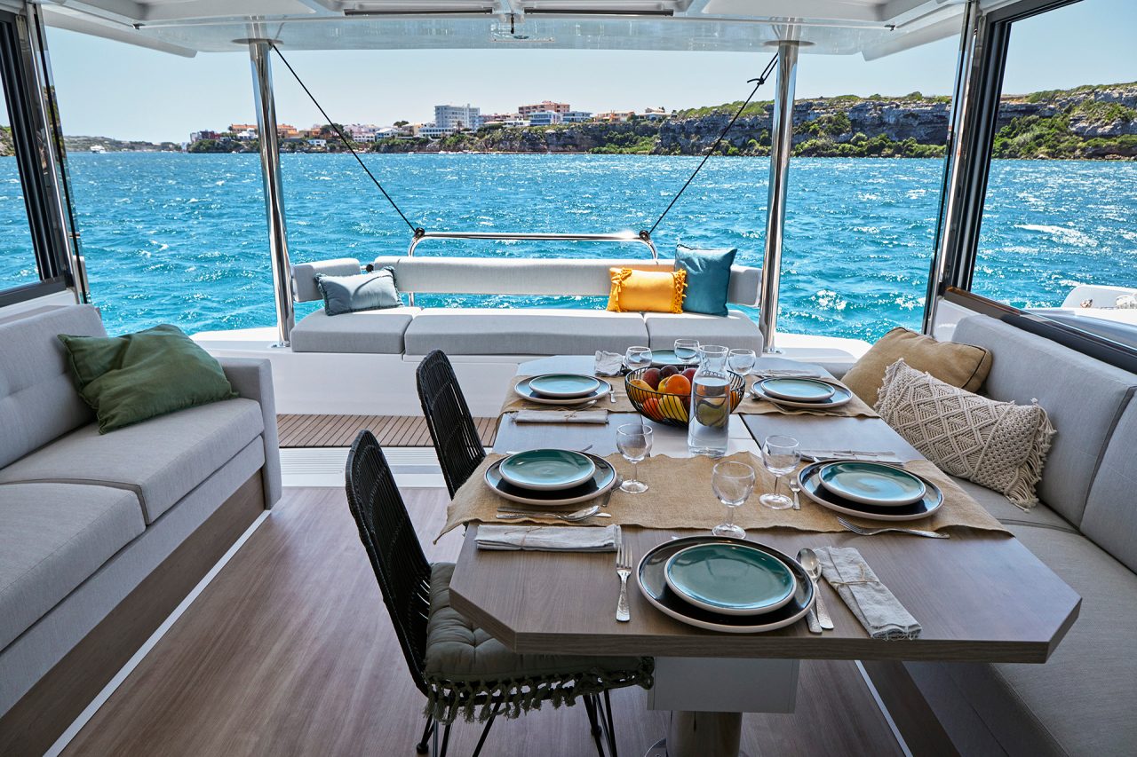 Interior dining area of the Bali 4.4 yacht with large door open to the sea