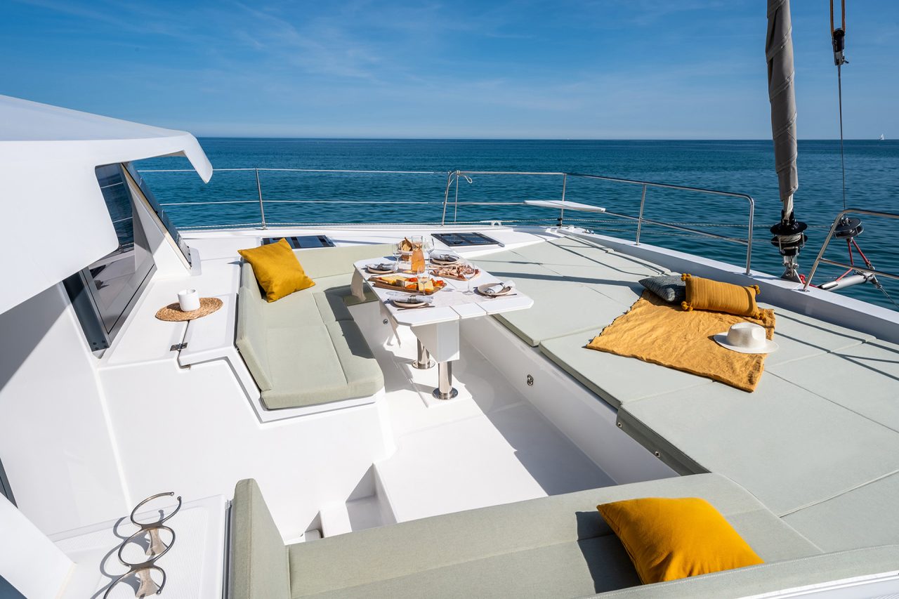 Front deck of the Bali 4.6 with cushioned sun lounge and dining table