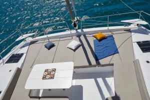 Front deck of the Bali 4.8 with cushioned sun lounge and dining table