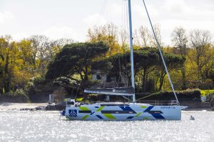 Side view of a Dufour 44 sailing monohull at anchor near scenic shoreline