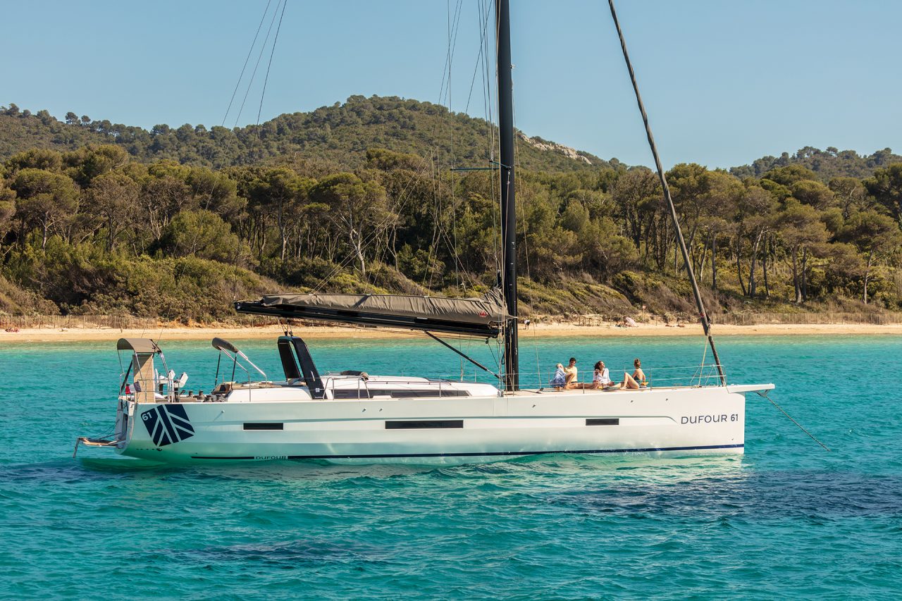 Dufour 61 yacht at anchor in bright blue waters