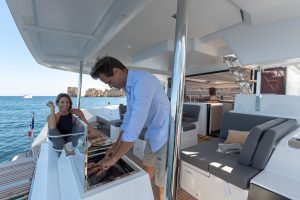 Man using outdoor grill on the Fountaine Pajot 67 catamaran electric