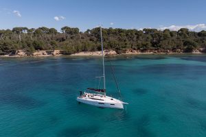 Jeanneau Sun Odyssey 350 monohull sailboat at anchor near shore