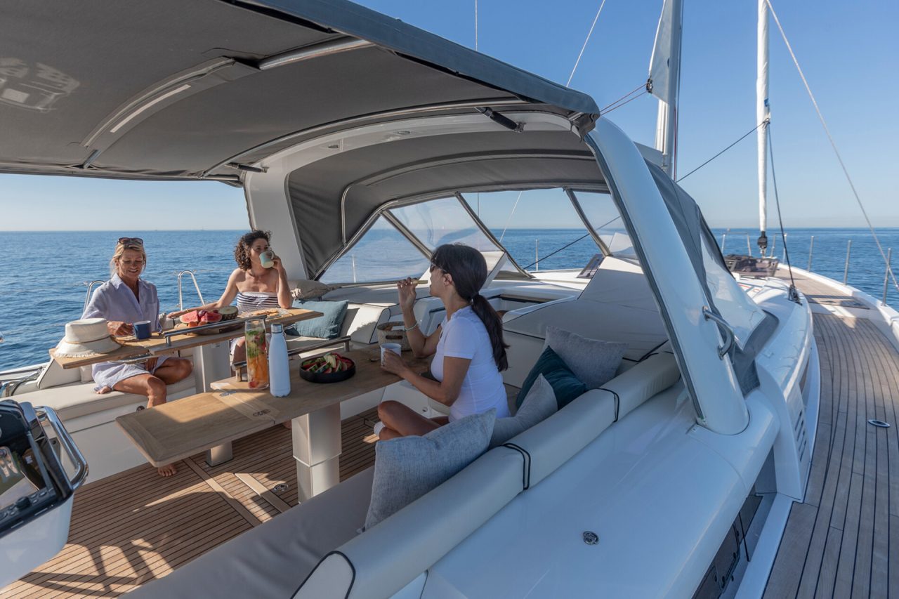 People at cockpit dinging table on Beneteau Oceanis Yacht 54 monohull