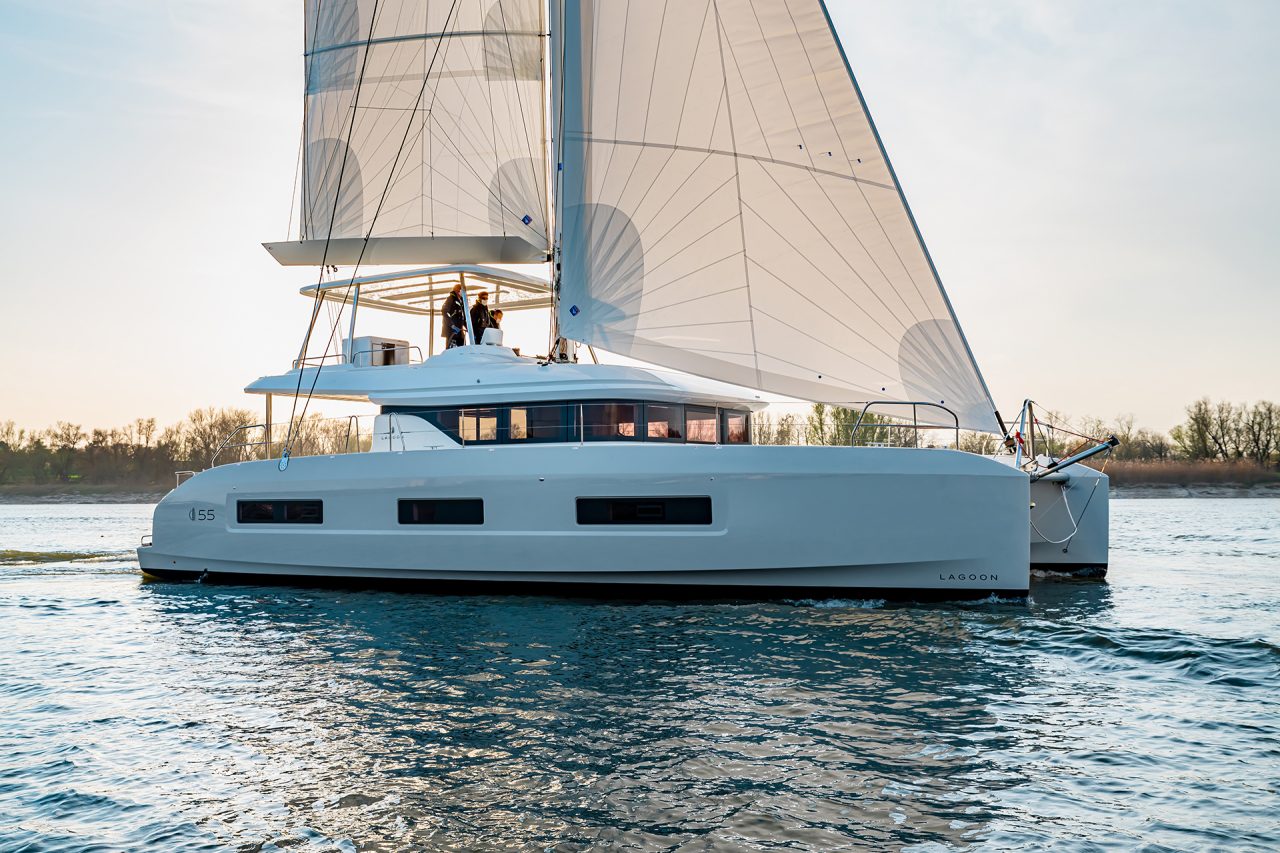 Side view of Lagoon 55 catamaran sailing at sunset