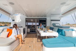 Couple seated in the cockpit of the Lagoon 55 sailing catamaran