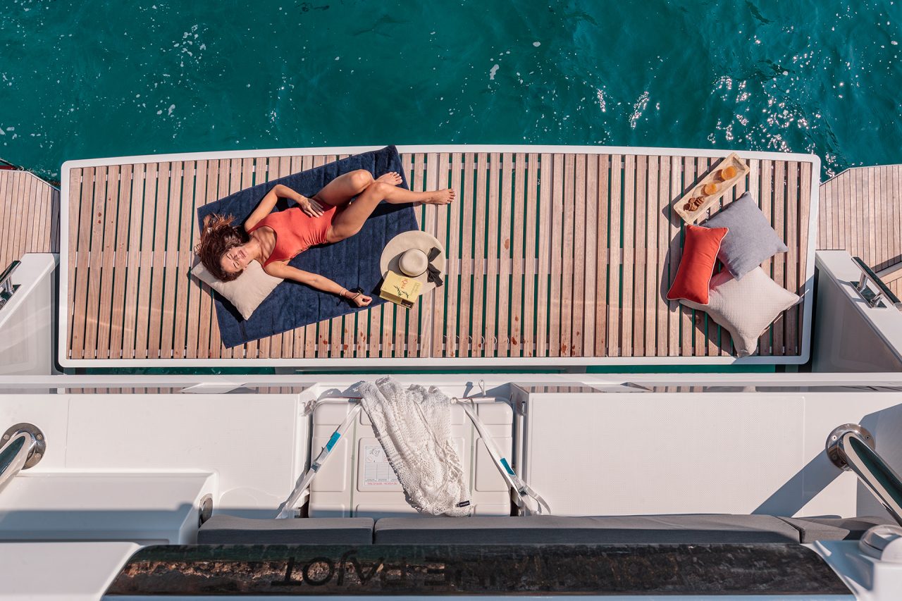 Woman sunning on the Fountaine Pajot 67 luxury catamaran platform